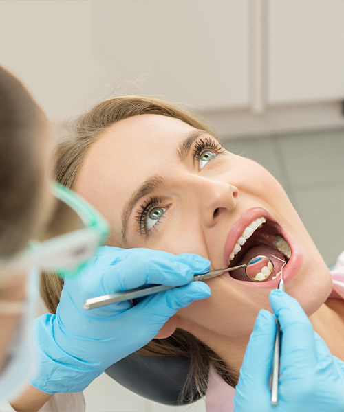 Composite fillings can be used to repair cavities or chipped teeth, as represented by this image of a woman in a dental chair.