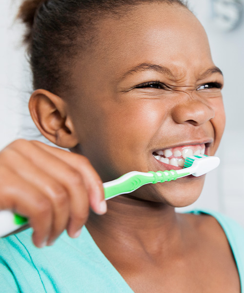 The tooth fairy kit can help children feel better about losing their baby teeth. A young girl brushes her teeth in this image.