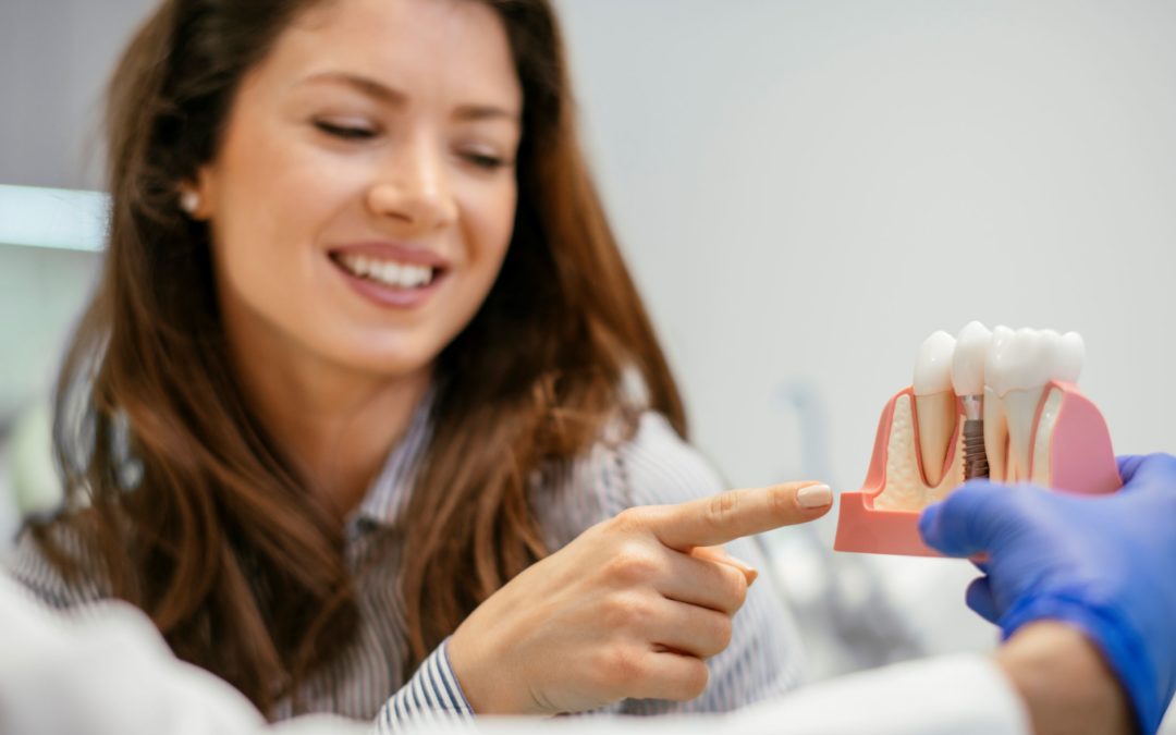 A woman talks with her dentist about the steps involved in a dental implant procedure.