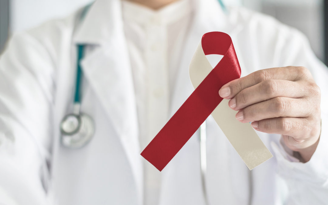 The dentist looks for signs of oral cancer during a regular checkup. This is a closeup image of a burgundy and ivory ribbon held by a doctor. The ribbon represents head and neck cancer, oral squamous cell carcinoma, throat, laryngeal and pharyngeal cancer awareness.